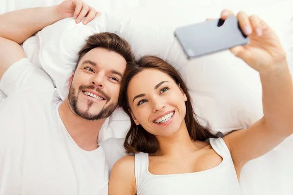 Couple faisant selfie au lit — Photo