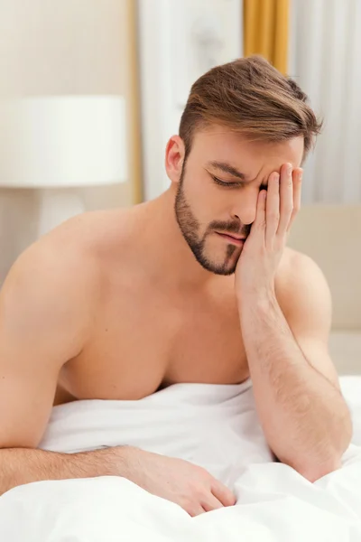 Mann sitzt im Bett — Stockfoto