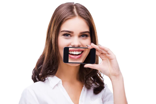 Woman holding phone against mouth — Stock Photo, Image