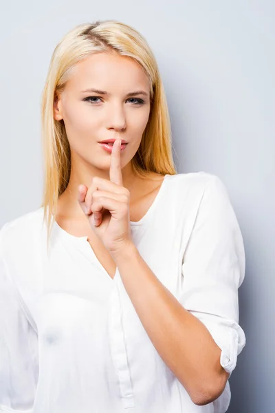 Vrouw bedrijf vinger op lippen — Stockfoto