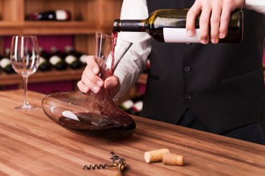 Sommelier pouring wine to decanter clipart