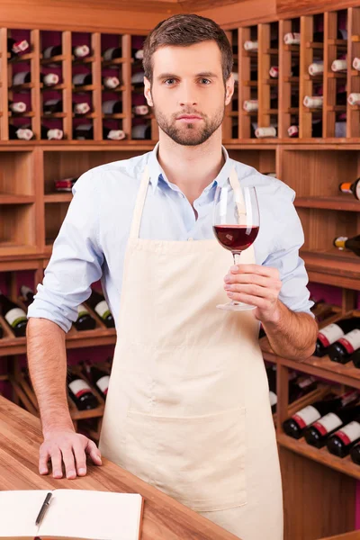 Man in apron holding glass — Stock Photo, Image