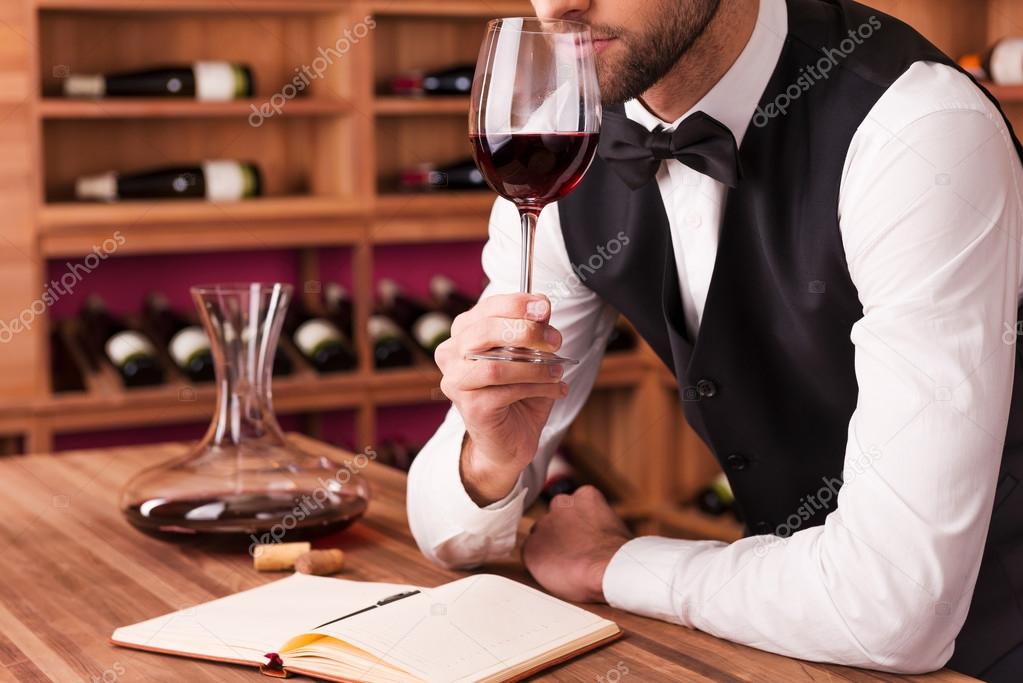 Male sommelier examining wine