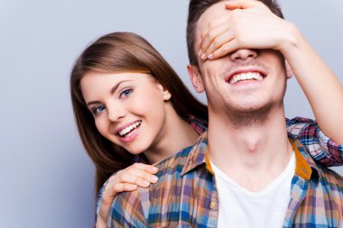 Woman covering eyes of  boyfriend clipart