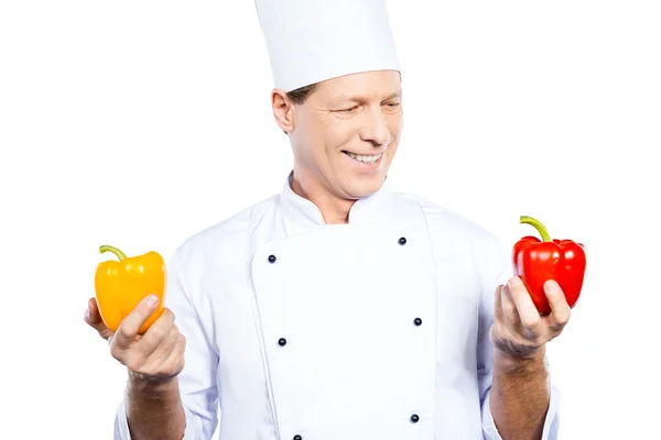 Mature chef holding colorful peppers — Stock Photo, Image