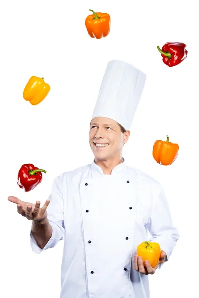 Chef malabarismo com pimentas coloridas — Fotografia de Stock