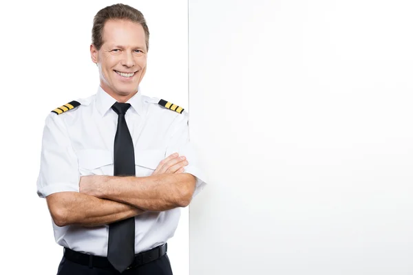 Pilot in Uniform lehnt am Kopierraum — Stockfoto