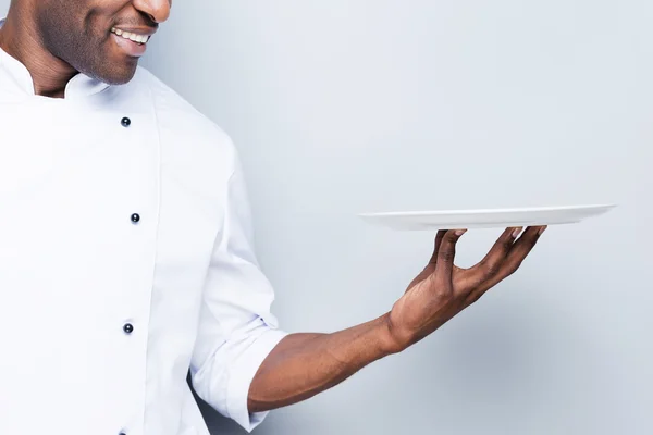 Chef africano in possesso di piatto vuoto — Foto Stock