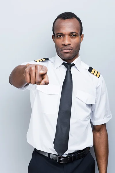 Serious African pilot pointing camera — Stock Photo, Image