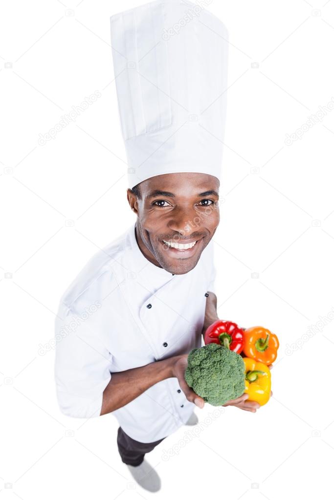 African chef holding vegetables