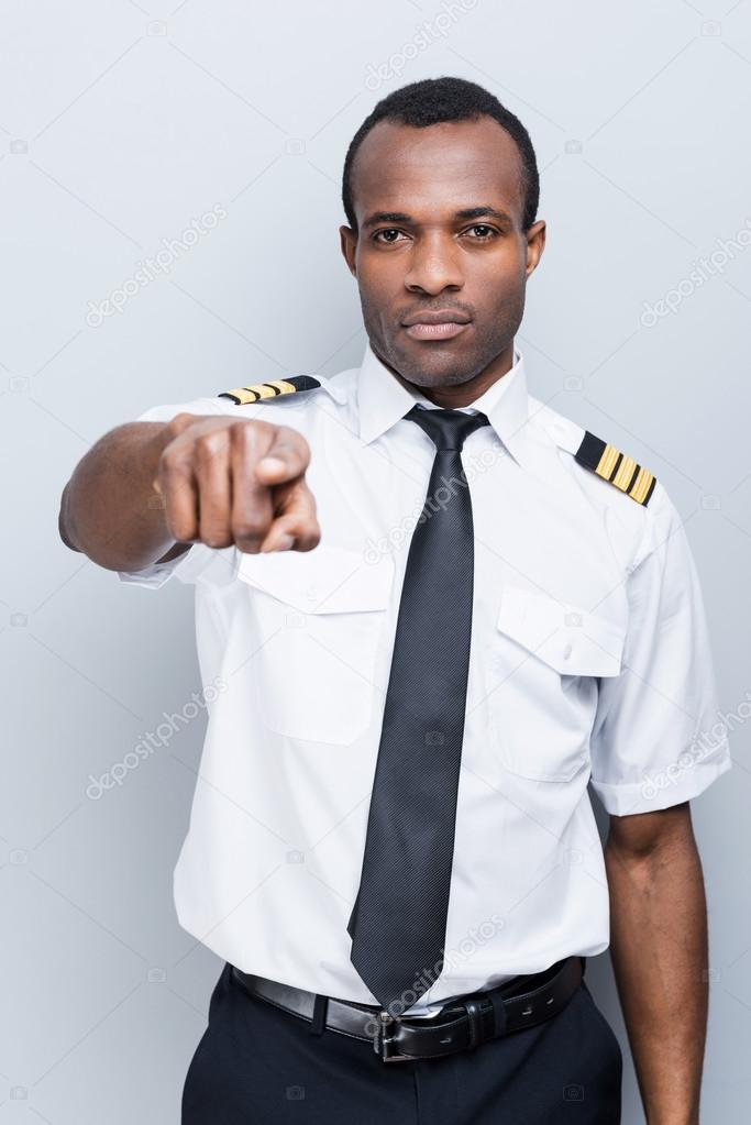 Serious African pilot pointing camera