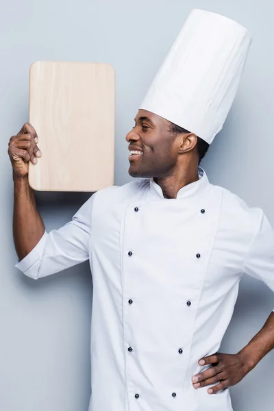 African chef carrying wooden cutting board — Stock Photo, Image