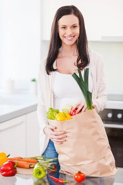 Jonge vrouw uitpakken boodschappentas — Stockfoto