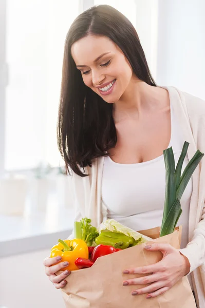 Jonge vrouw uitpakken boodschappentas — Stockfoto