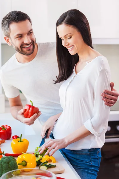 Vrouw snijden groenten met haar man — Stockfoto