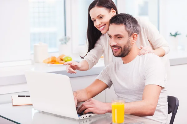 Hombre trabajando en el ordenador portátil con su novia — Foto de Stock
