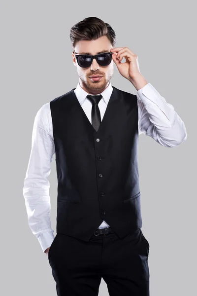 Uomo in abito formale che regola i suoi occhiali da sole — Foto Stock
