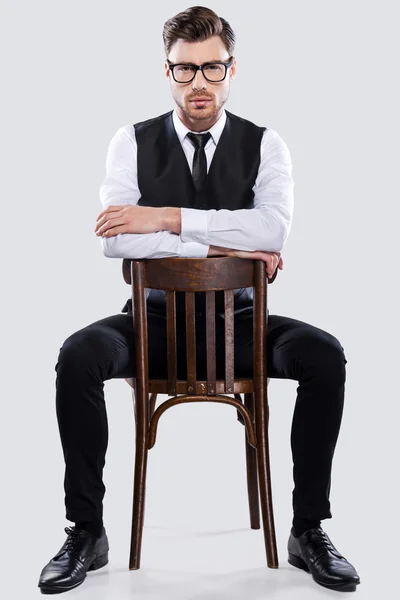 Handsome young man sitting at chair — Stock Photo, Image