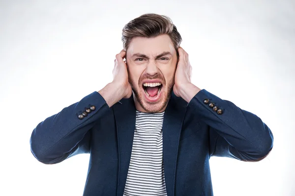 Furious man grimacing and covering ears — Stock Photo, Image