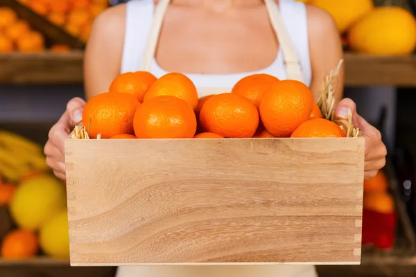 Mandalina ile ahşap kapsayıcı tutan kadın — Stok fotoğraf