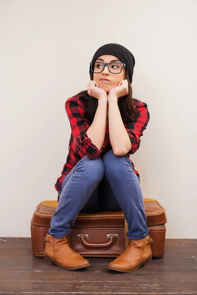 Woman in headwear sitting on suitcase — Stock Photo, Image