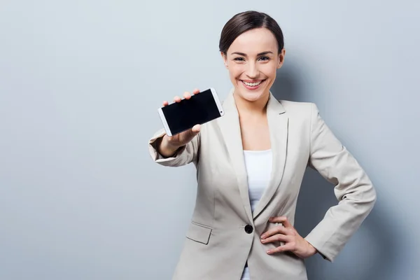 Businesswoman stretching out mobile phone — Stock Photo, Image