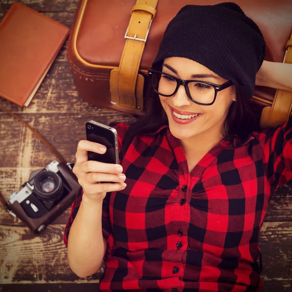 Kvinnan håller mobiltelefon och ler — Stockfoto