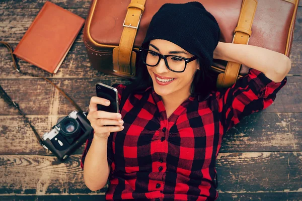 Woman holding mobile phone and smiling — Stock Photo, Image