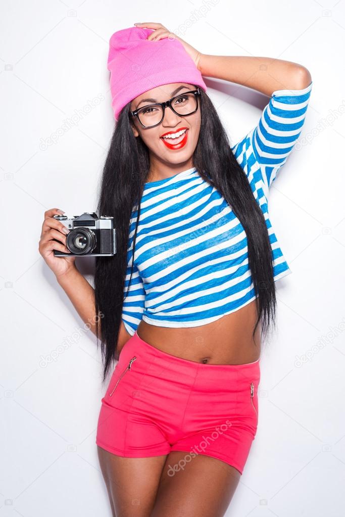 African woman holding camera and smiling