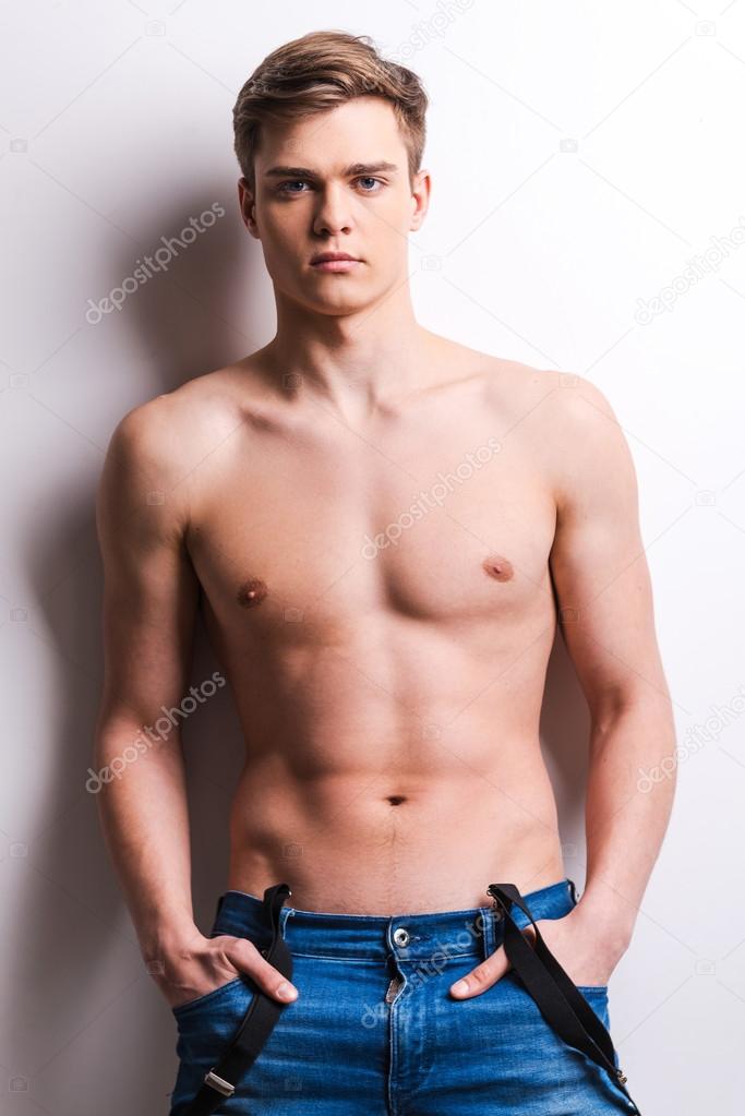 Muscular man holding hands in pockets