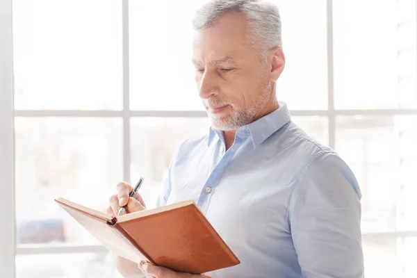 Uomo anziano prendere appunti di lavoro — Foto Stock