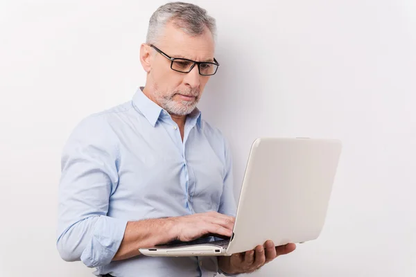 Senior man werkt aan laptop — Stockfoto