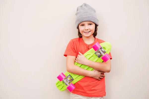 Malý chlapec hospodářství barevné skateboard — Stock fotografie