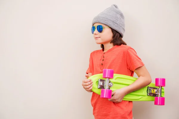 Menino segurando skate colorido — Fotografia de Stock