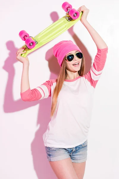 Giocoso giovane ragazza in possesso di skateboard — Foto Stock