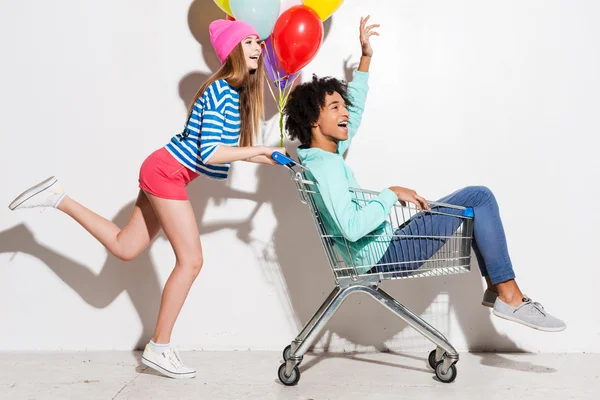 Alışveriş sepeti içinde erkek arkadaşı taşıyan kız — Stok fotoğraf