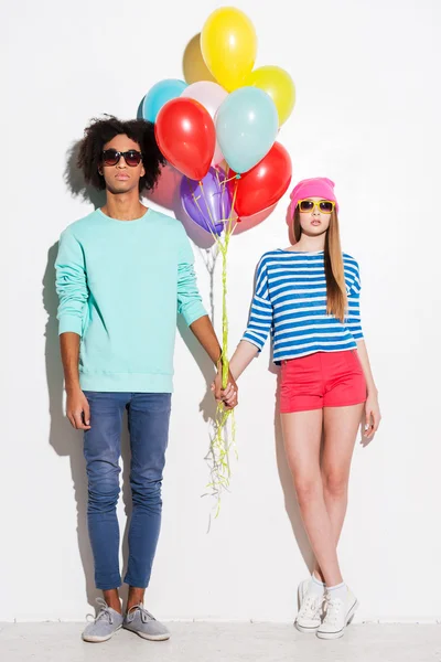 Funky young couple holding balloons — Stock Photo, Image