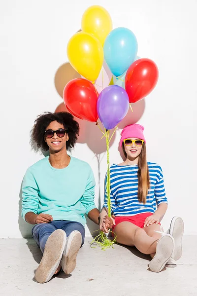 Young couple holding balloons — Stock Photo, Image