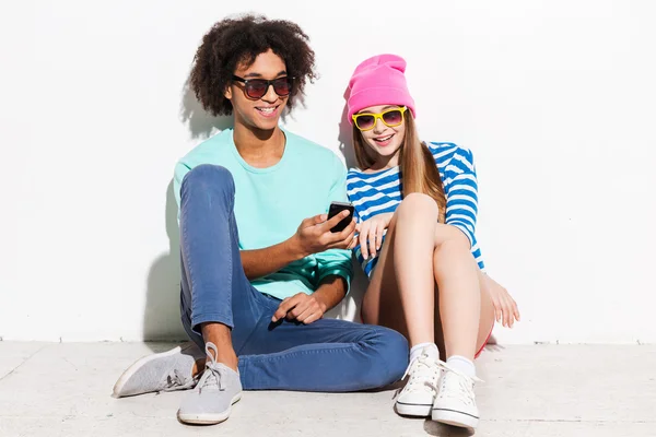 Unga par tittar på mobiltelefon — Stockfoto