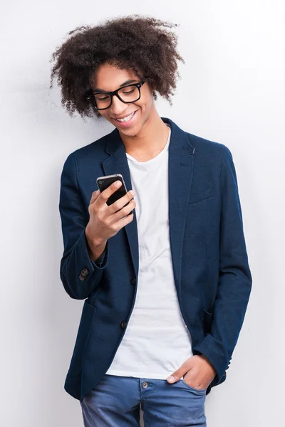 Ung afrikansk man håller mobiltelefon — Stockfoto