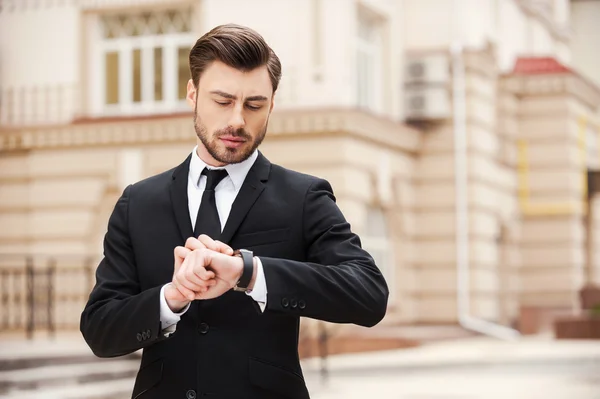 Giovane uomo d'affari guardando orologio — Foto Stock