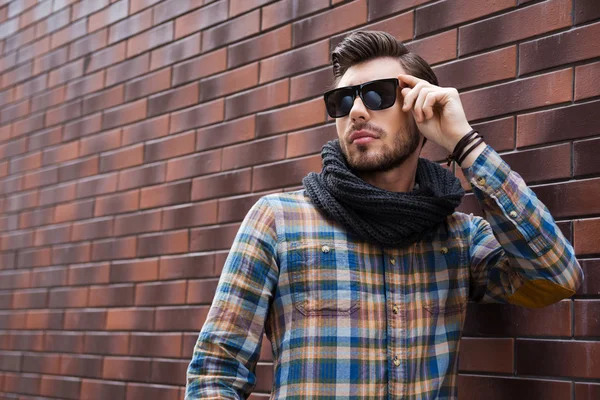 Hombre joven guapo ajustando gafas de sol — Foto de Stock