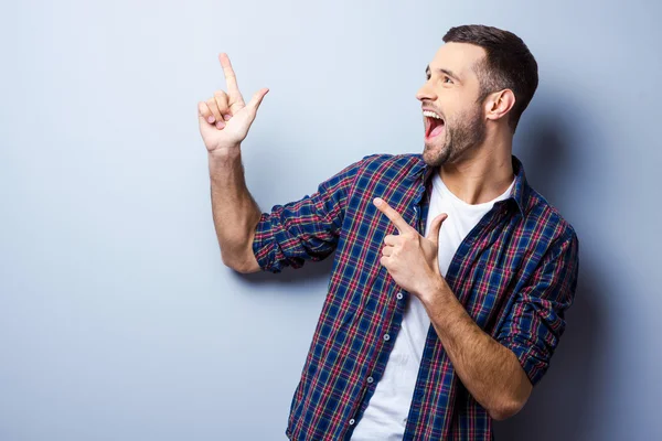 Jovem feliz apontando para longe — Fotografia de Stock