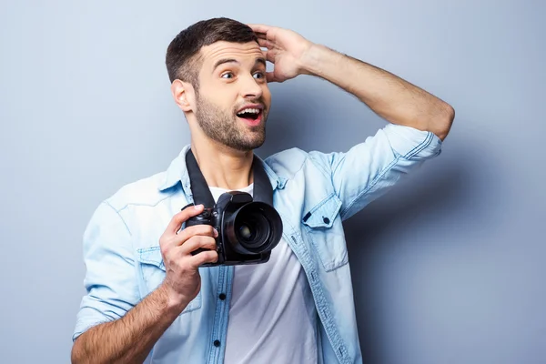 Homem animado segurando câmera digital — Fotografia de Stock