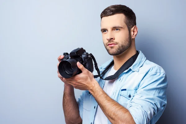 Jonge man bedrijf digitale camera — Stockfoto