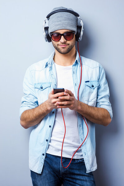 Hombre con estilo en auriculares que sostienen MP3 — Foto de Stock