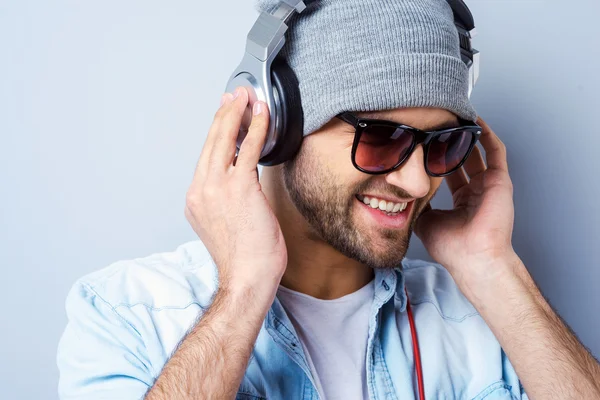 Jonge man zijn hoofdtelefoon aanpassen — Stockfoto