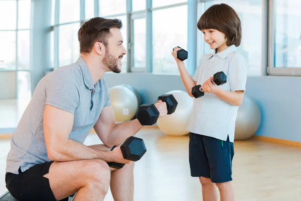 Padre e hijo haciendo ejercicio con pesas — Foto de Stock