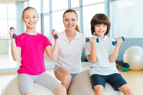 Instructor que ayuda a los niños a hacer ejercicio —  Fotos de Stock