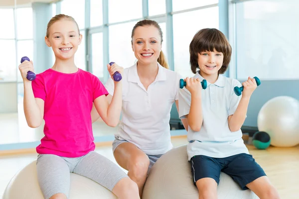 Ausbilder hilft Kindern beim Turnen — Stockfoto